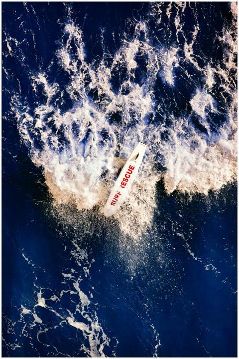 A surf rescue boat navigates powerful ocean waves