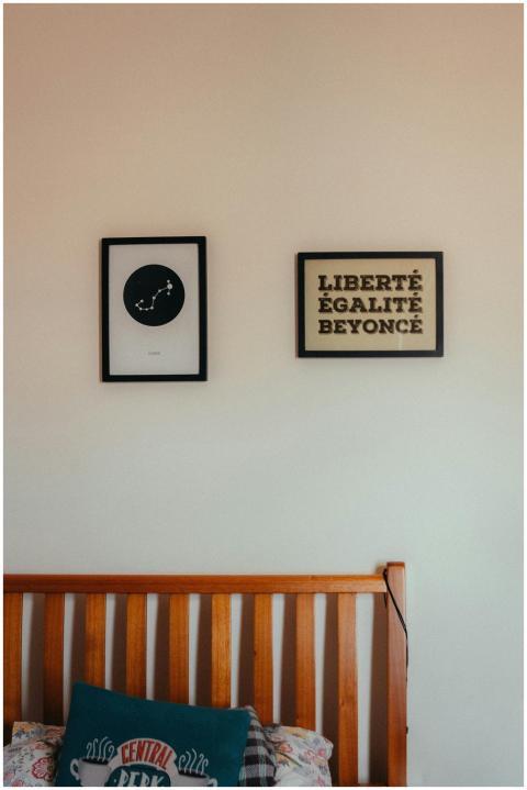 A cozy bedroom featuring framed wall art above a w