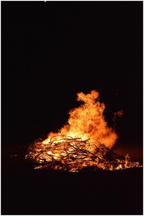 A powerful bonfire burning at night, casting light