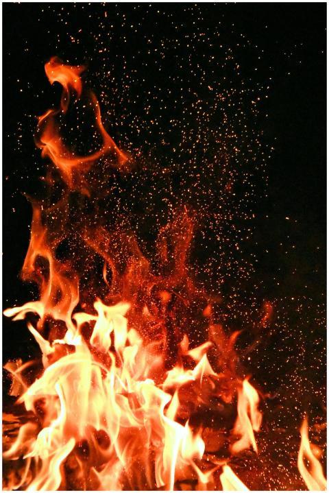 Vivid orange flames and sparks dance against a mys