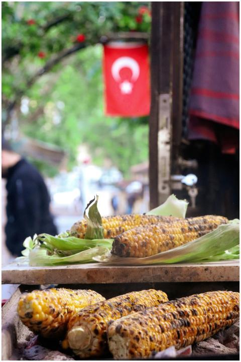 Grilled corn on display in a vibrant Turkish stree