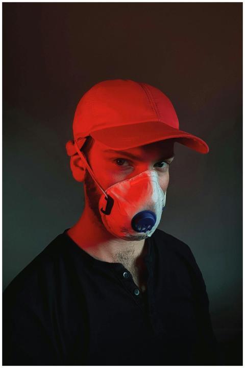 Portrait of a man wearing a mask and red baseball