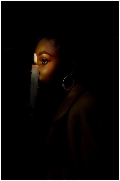 A dramatic portrait of a woman illuminated by cand