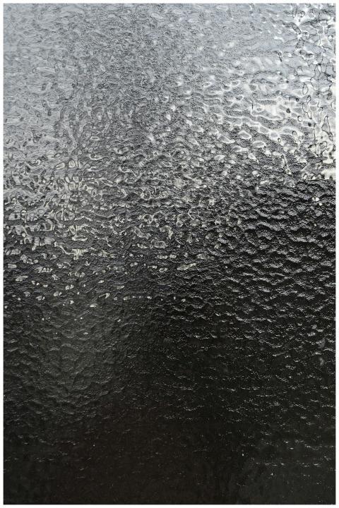 Close-up of a textured frosted glass surface, capt