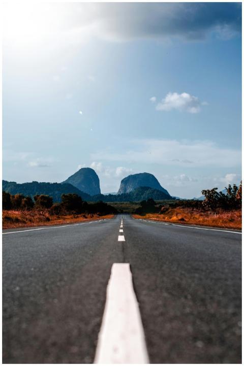 Long straight road leading to distant mountains un