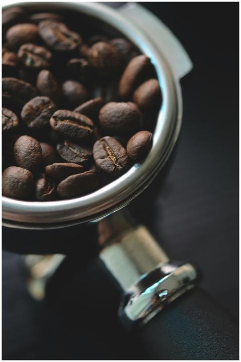Aromatic coffee beans resting in a metal portafilt