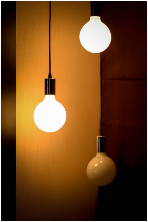 Composition of three glowing light bulbs creating