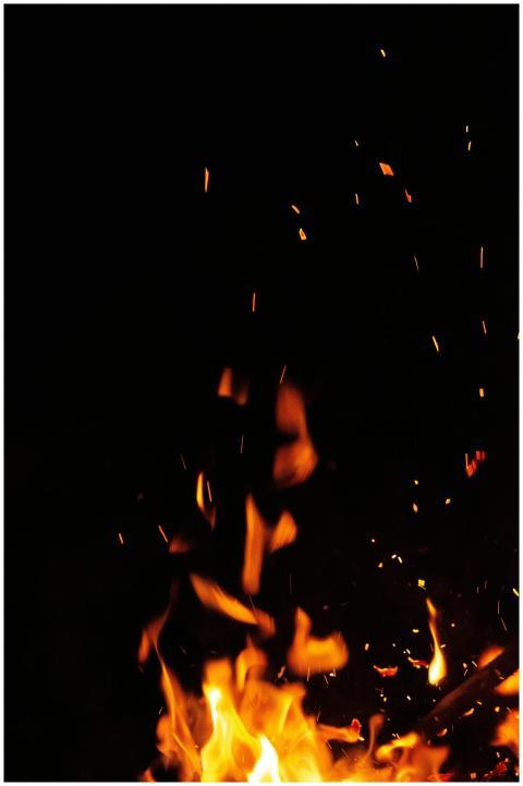 Close-up of bright flames and sparks in the dark n
