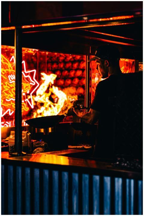 A vibrant scene of a street food vendor cooking in