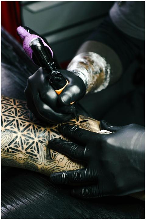 Tattoo artist working on intricate black and white