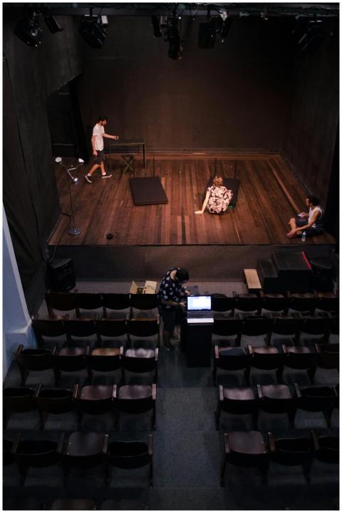Actors rehearsing on stage in an empty theater, vi
