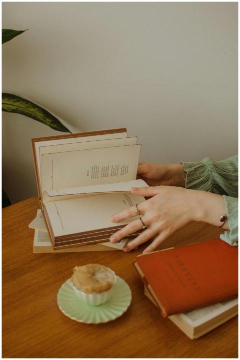 High angle of crop anonymous woman reading books a