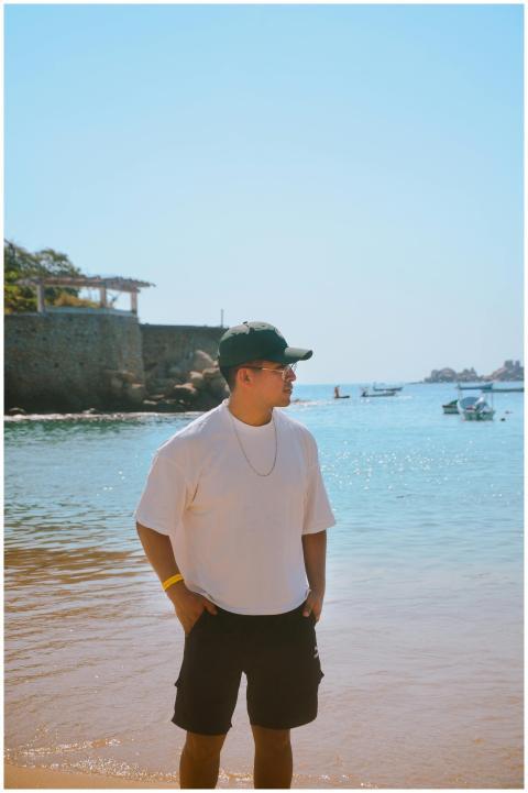 Young man wearing casual summer attire stands by t