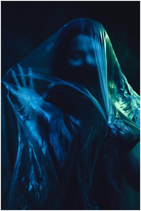 Dark and mysterious figure behind plastic sheet cr