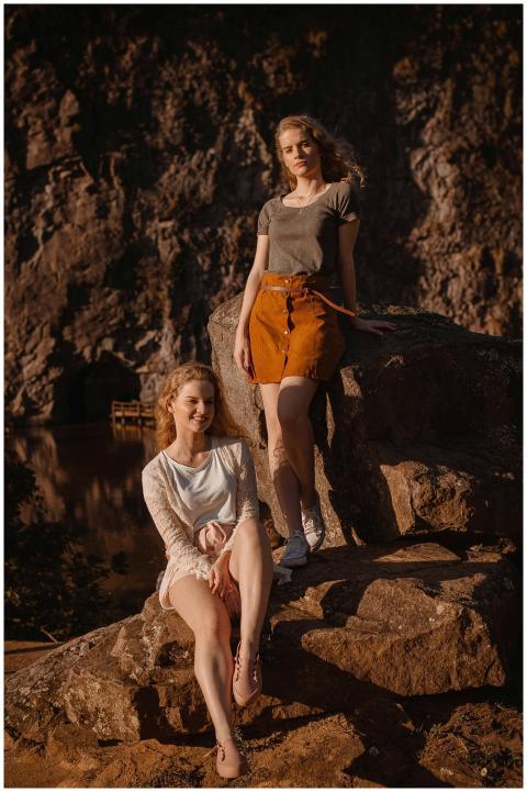 Two young women in stylish outfits posing on sunli