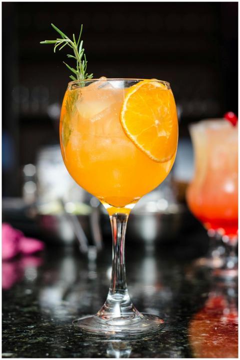Refreshing orange cocktail with ice, garnished wit