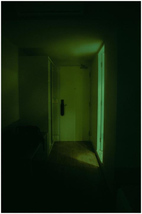 Dark hallway with a closed door, illuminated softl