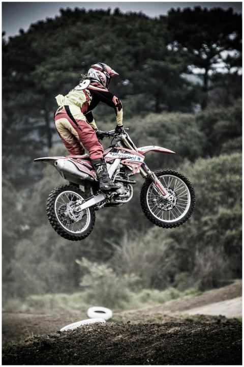 Motorcyclist executing a high jump during an outdo