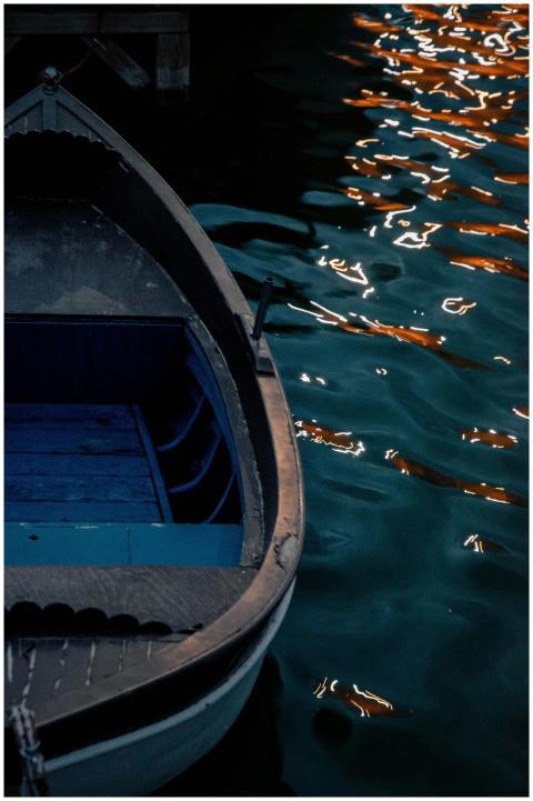 A tranquil night scene of a rowboat docked by shim