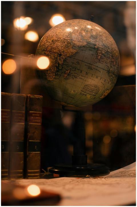 Through glass of world globe and ancient books pla