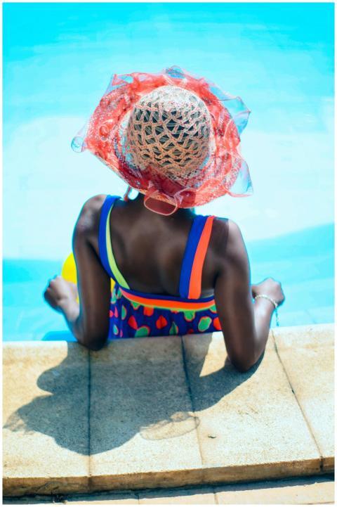 A woman enjoying the summer sun, relaxing by a swi
