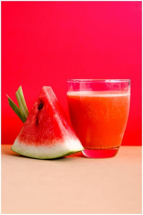 Refreshing watermelon juice and slice against a vi