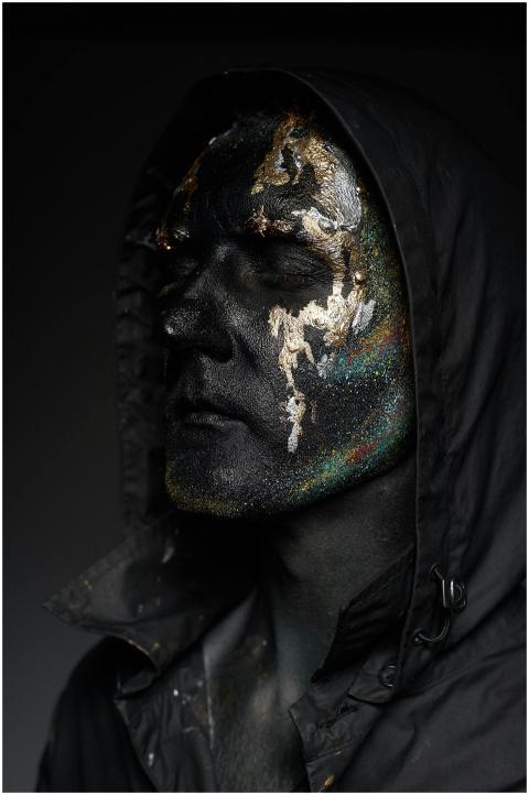 Close-up of a man with glittery face paint wearing