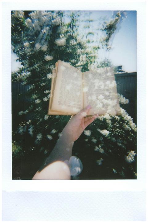 Artistic double exposure of a hand holding a book