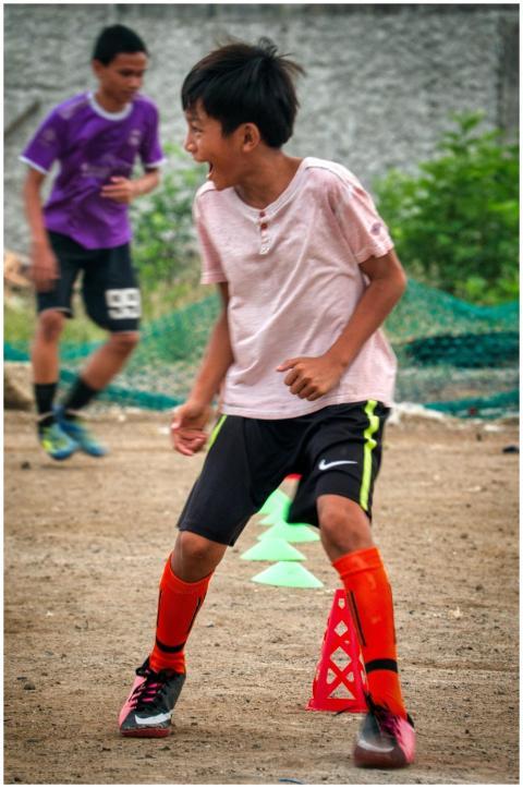 Two boys playing soccer outdoors, showcasing energ