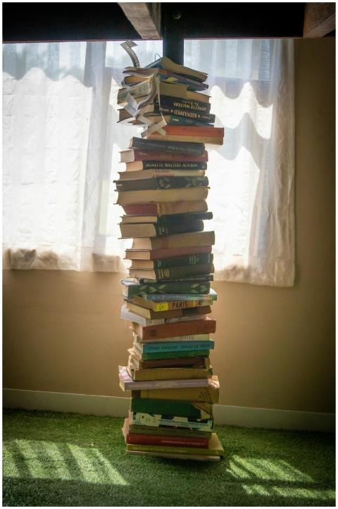 A tall stack of books casting a shadow near a sunl