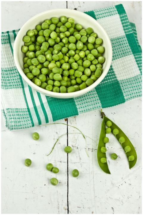 A vibrant display of green peas in a bowl with a r