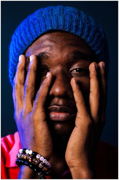 Close-up portrait of a black man wearing a blue be
