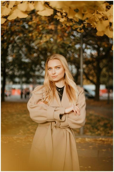 Stylish woman in autumn attire posing in a park su