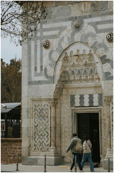 Two individuals walking into an ornate historic bu