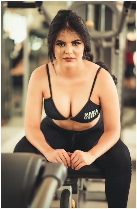 Confident woman in workout attire sitting on a ben