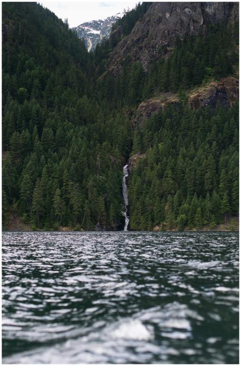Tranquil lake with cascading waterfall in a lush g