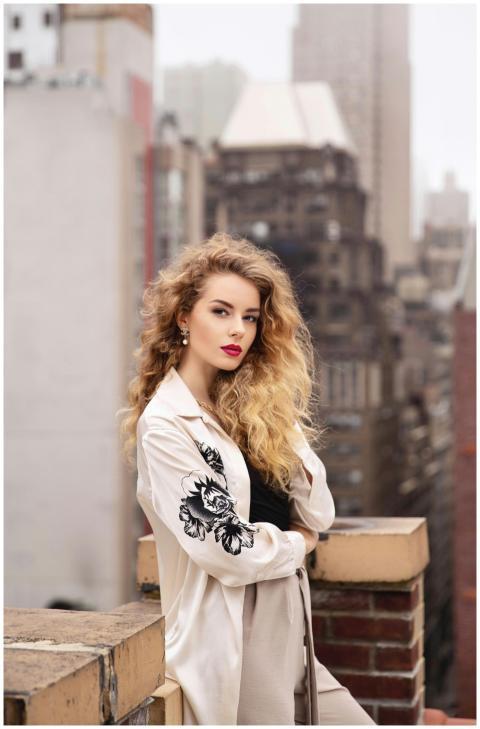 Stylish woman with curly hair posing amid the urba