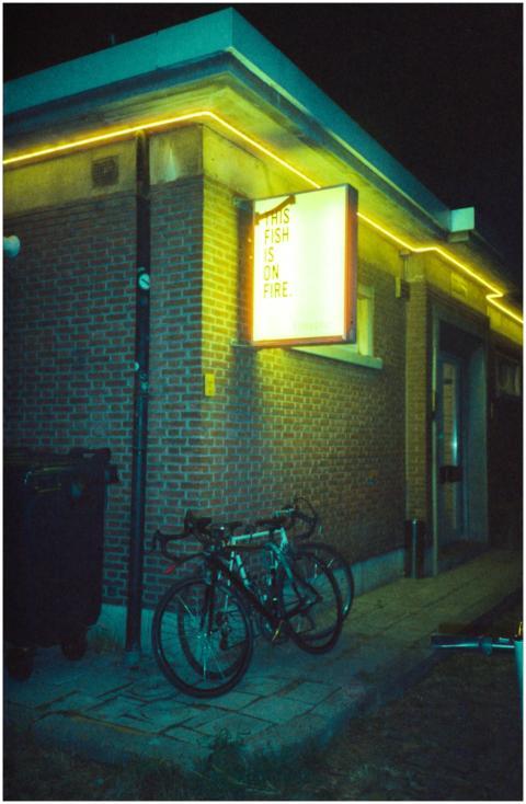 Urban night scene with neon sign and bicycles agai