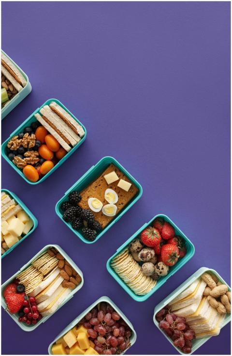 Flat lay of diverse snacks in plastic containers o