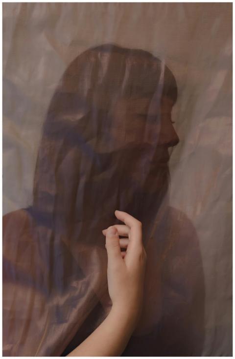 Silhouette of a woman covered by a sheer fabric, c