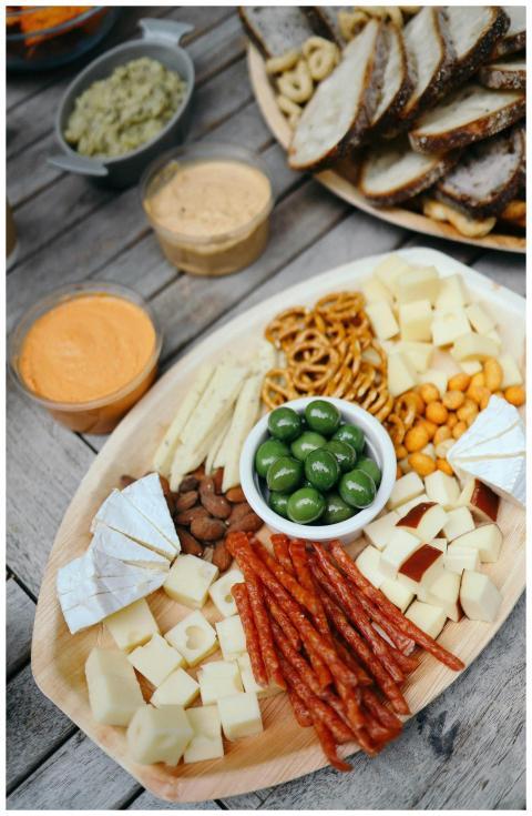 A rustic platter with an assortment of cheeses, me