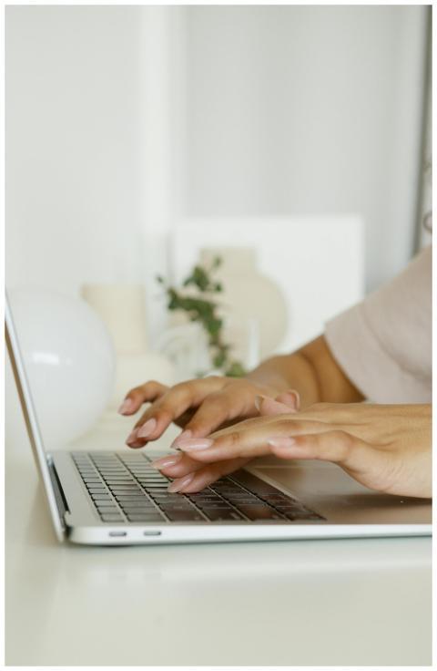 A detailed view of hands typing on a laptop, ideal