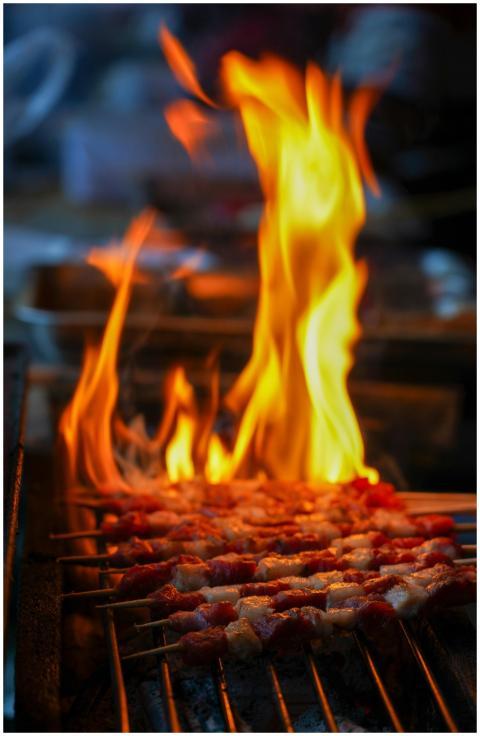 Juicy meat skewers being grilled over an open flam
