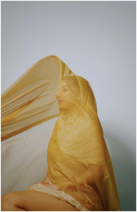 Artistic portrait of a woman sitting under a trans