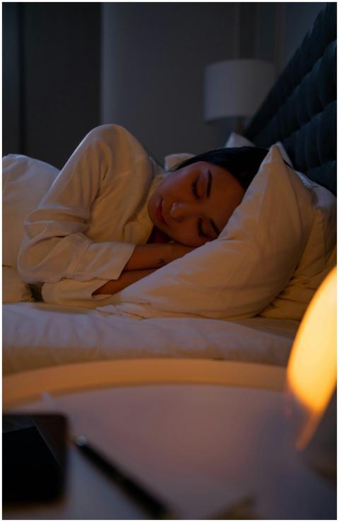 A peaceful woman rests in a serene bedroom environ