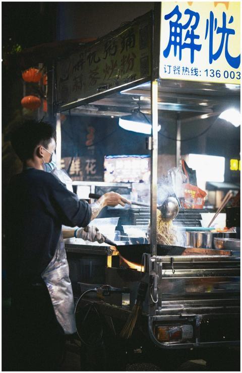 A street food vendor prepares food at a bustling n