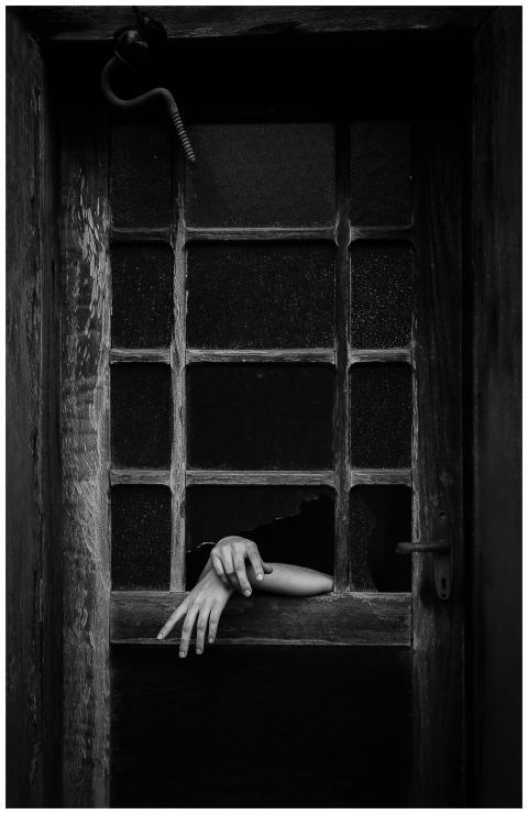 Black and white photo of a hand reaching through a