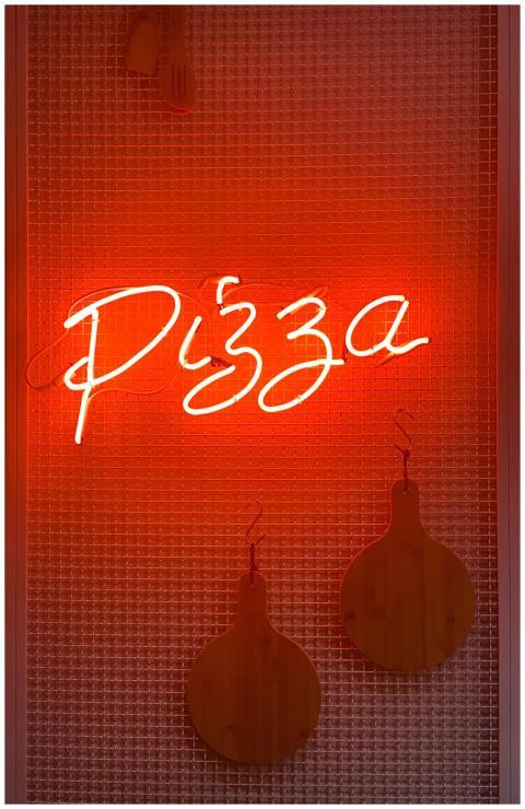 A glowing neon sign displaying the word 'Pizza' on