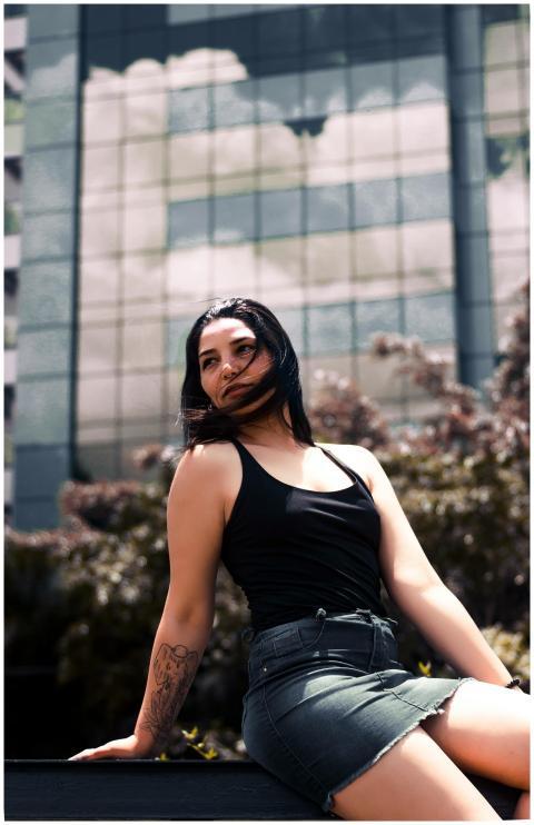 Stylish woman sitting in an urban setting, showcas