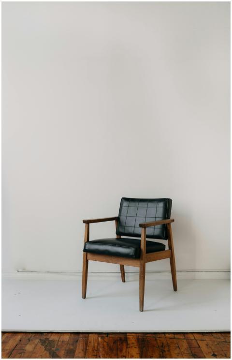 A vintage leather armchair placed against a plain
